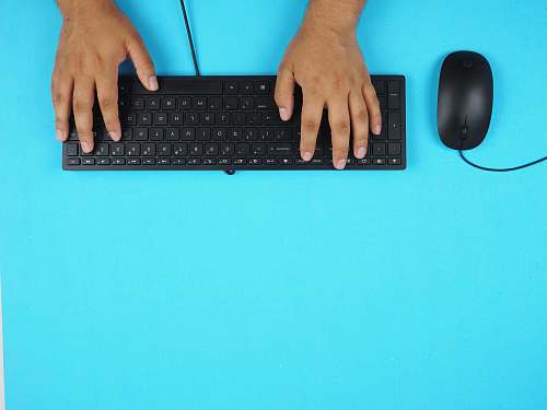 computer hardware person holding black corded computer keyboard computer keyboard